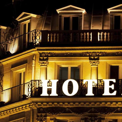 brightly-lit-hotel-sign-on-a-hotel-balcony-157695209-5bfd5c2046e0fb00517b7ffd